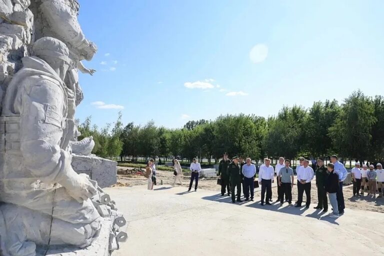 В Волгограде завершается возведение скульптурной композиции, посвящённой участникам специальной военной операции. В ходе рабочей поездки ход работ оценили высокопоставленные лица: губернатор Андрей Бочаров, глава Волгограда Владимир Марченко, заместитель Министра обороны РФ Александр Санчик и председатель Волгоградской областной Думы Александр Блошкин.  Сейчас памятник, расположенный у подножия Мамаева кургана, практически готов — активно ведётся оформление прилегающей территории. Скульптурная композиция создаётся в три смены, чтобы успеть завершить все работы в срок.  Монумент впечатляет своими масштабами: его высота достигает 7 метров, а длина — 14 метров. Композиция клиновидной формы состоит из двух блоков с фрагментами личных посланий бойцов своим родным. Центральное место в ансамбле занимает фигура солдата с обнажённым торсом — этот художественный приём отсылает к творческому почерку Евгения Вучетича, автора знаменитого мемориала на Мамаевом кургане.  Идея памятника стала по-настоящему народной: в разработке концепции участвовали около ста тысяч жителей региона, а также сами участники спецоперации. На завершающем этапе к реализации проекта подключились мастера студии военных художников имени Митрофана Грекова. Правовой статус мемориала закреплён соответствующим законом Волгоградской областной Думы.